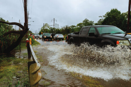 Flooded feeder street splash by a car Heavy rains from hurricane Harvey caused many flooded